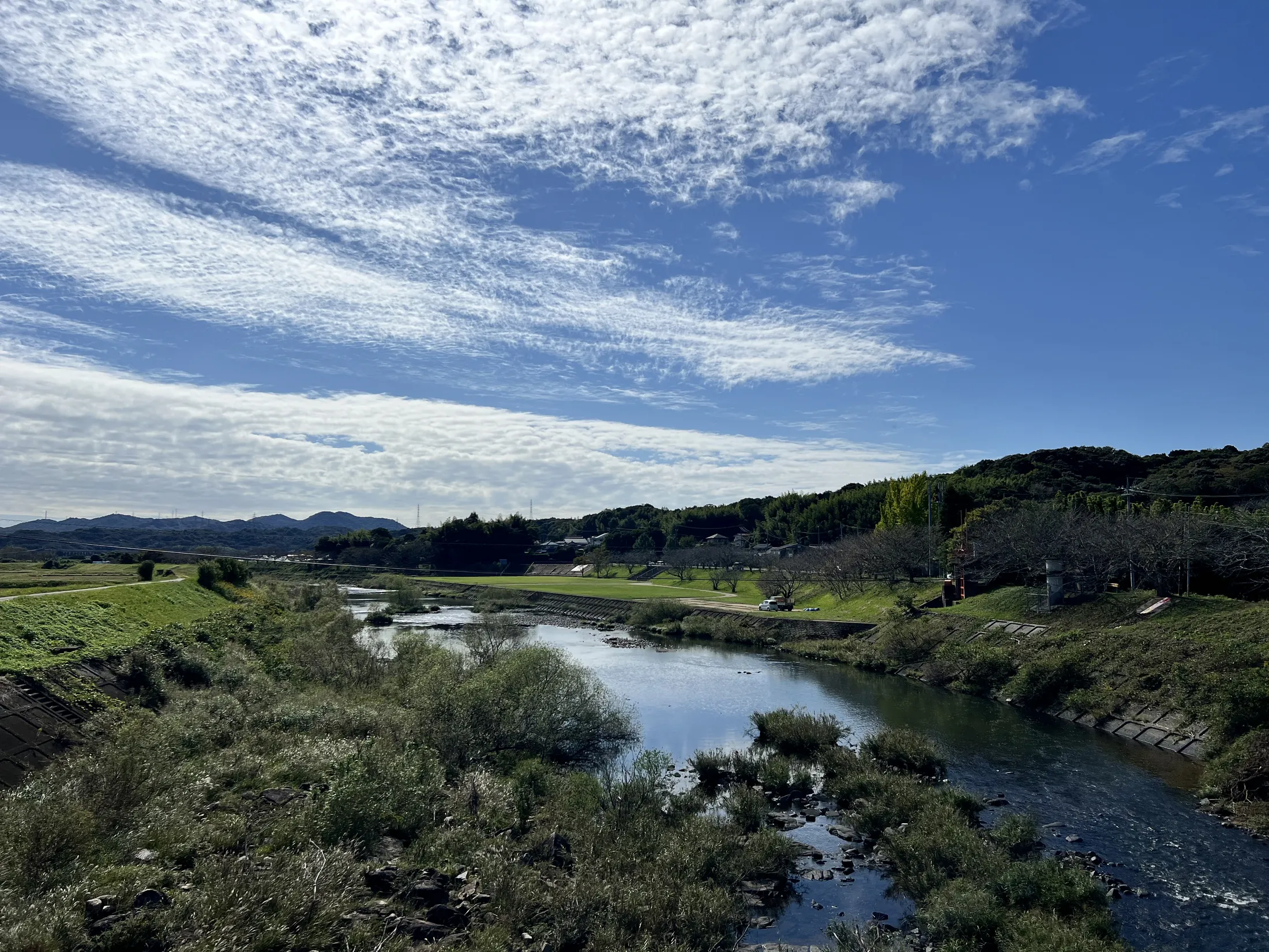 A quiet river moving through a soft, low-saturation landscape